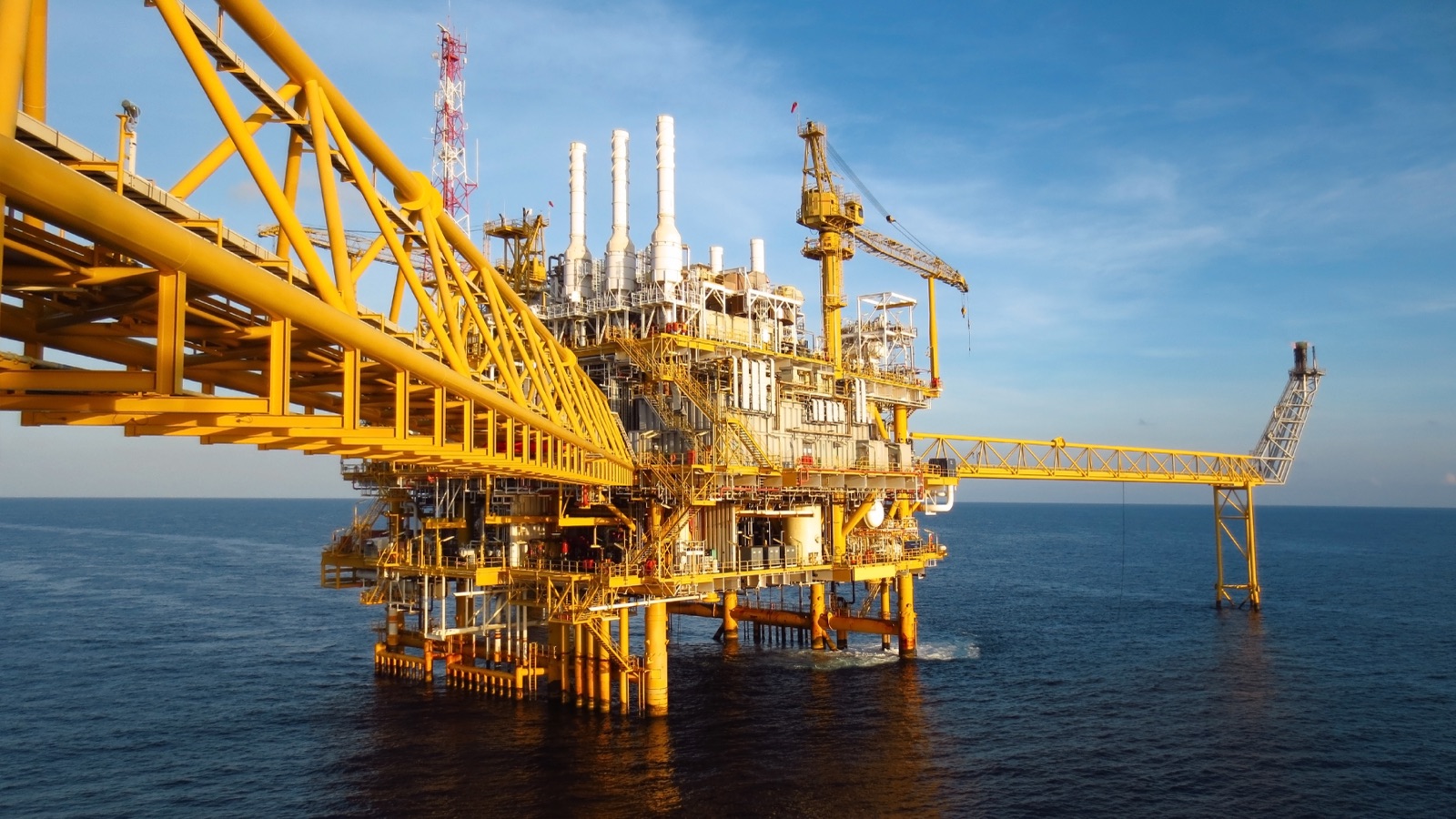 Offshore platform with yellow crane structures at sea